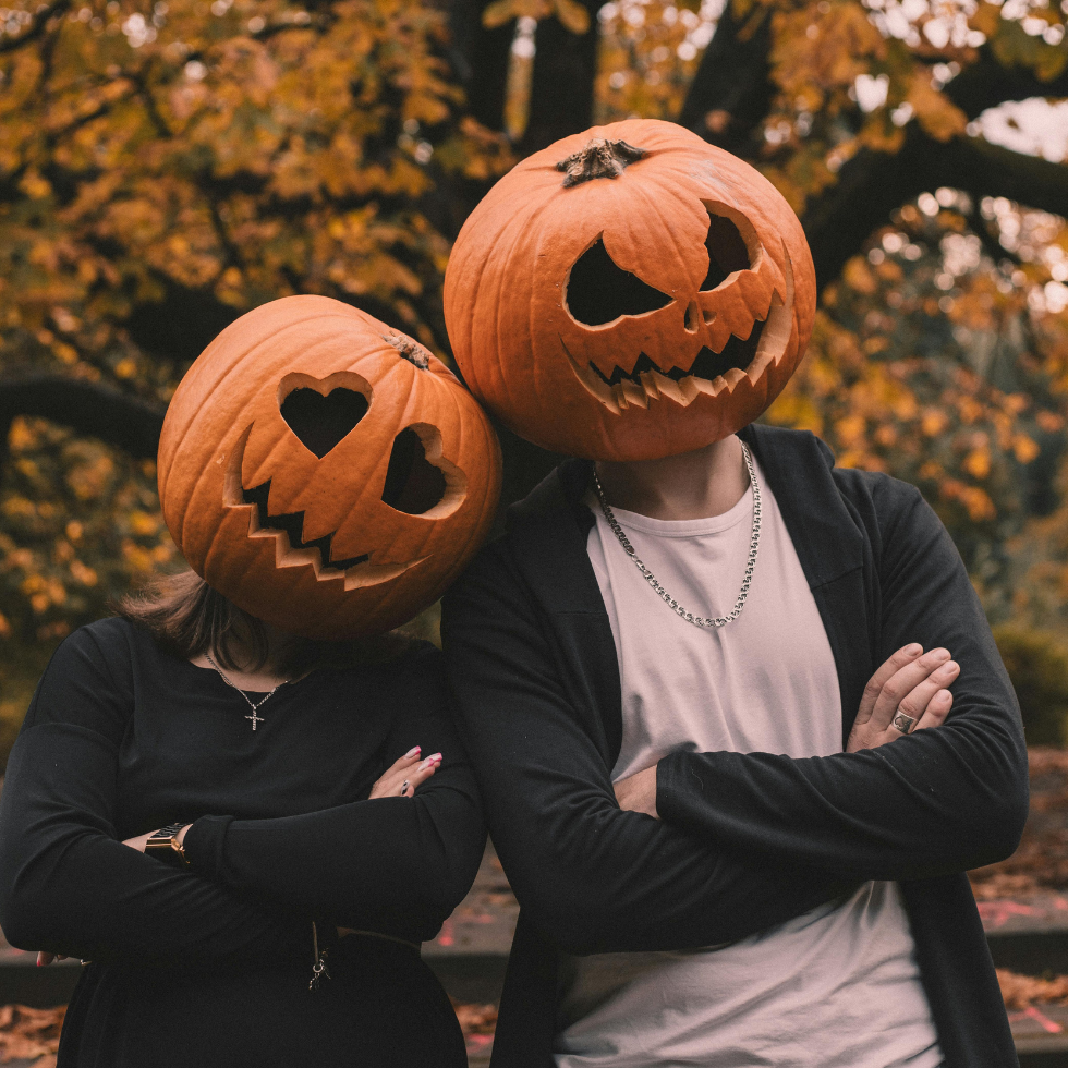 Halloween Paarkostüme, Paar mit ausgehöhlten Kürbissen auf dem Kopf