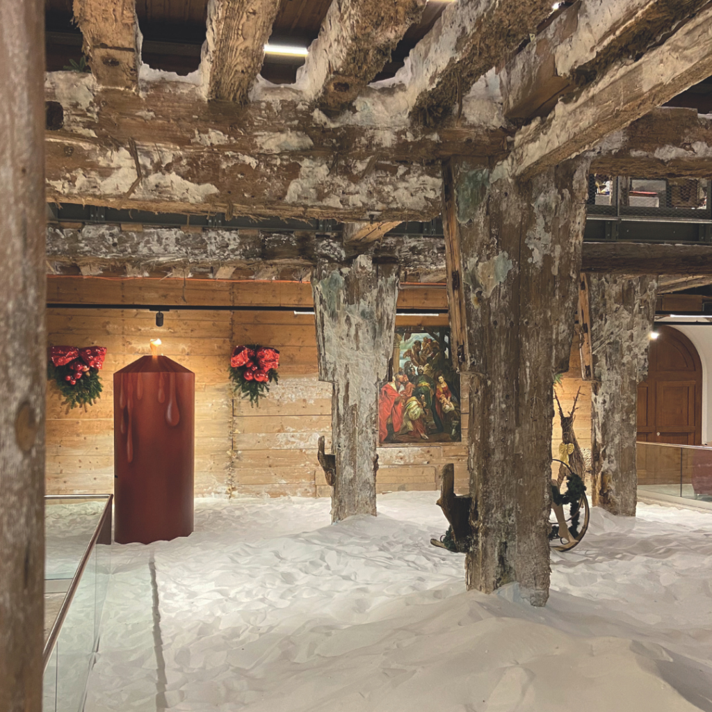 Weihnachtsmarkt in der Alten Saline Hallein, urige, weihnachtliche Stimmung mit altem Holzgewölbe und einer lebensgroßen Kerze