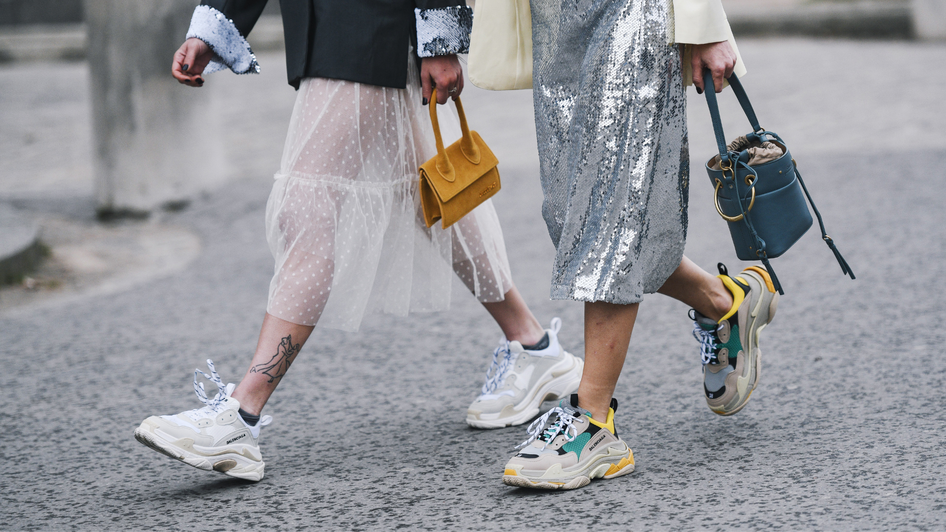 Tirolerin Outfit-Ideen, Thema Röcke, zwei Frauen gehen in stylischen Outfits der Straße entlang, detaillierte Aufnahme, Sneaker, Sporty Spice