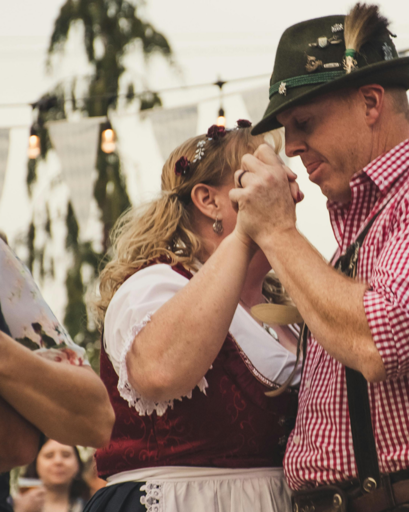 Ein Pärchen in Tracht gekleidet tanzen miteinander
