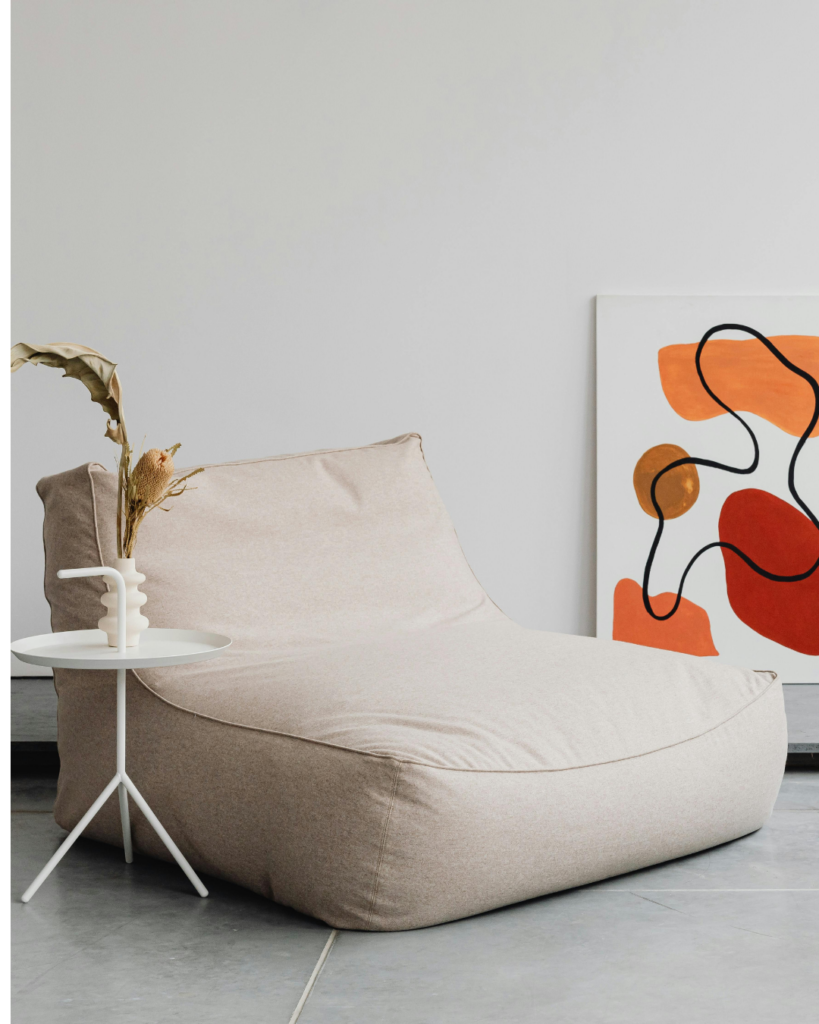 Sessel beige mit Beistelltisch und Bild im Hintergrund