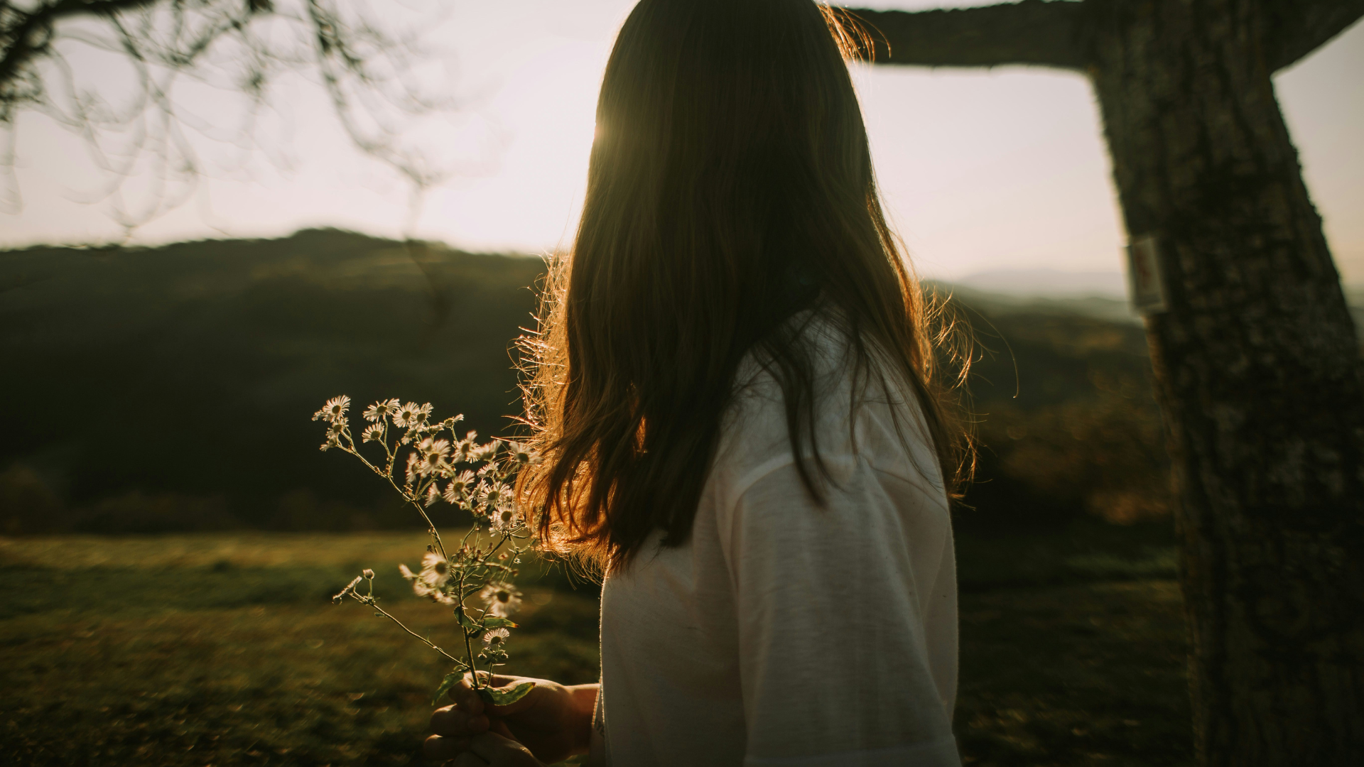 Frau mit Blumen in der Hand blickt in die Ferne