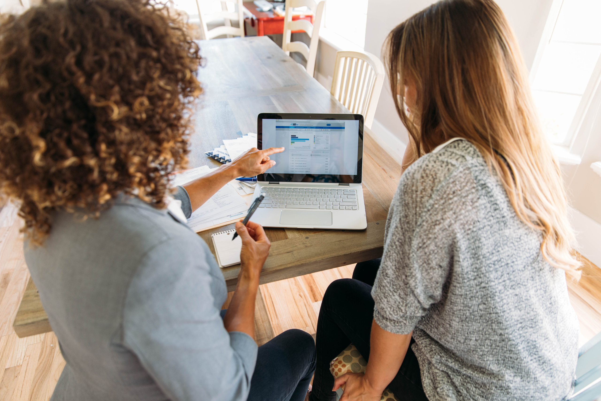 Helfen macht glücklich, Symbolfoto 2 Frauen vor Laptop