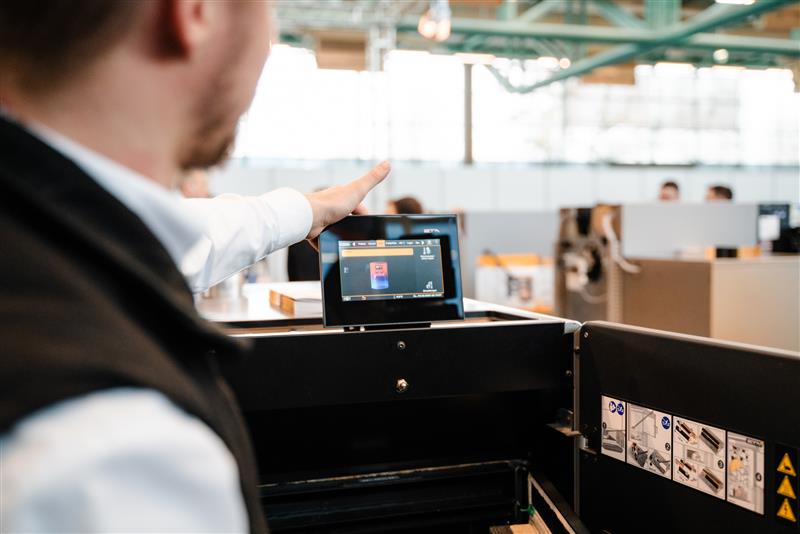 Auf einer Messe, ein Mann zeigt einen kleinen Bildschirm her