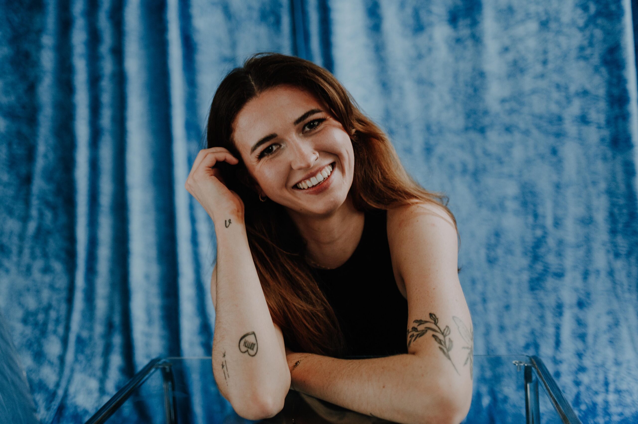 Portraitbild von Steffi Harms, blauer Hintergrund, sie lächelt in die Kamera