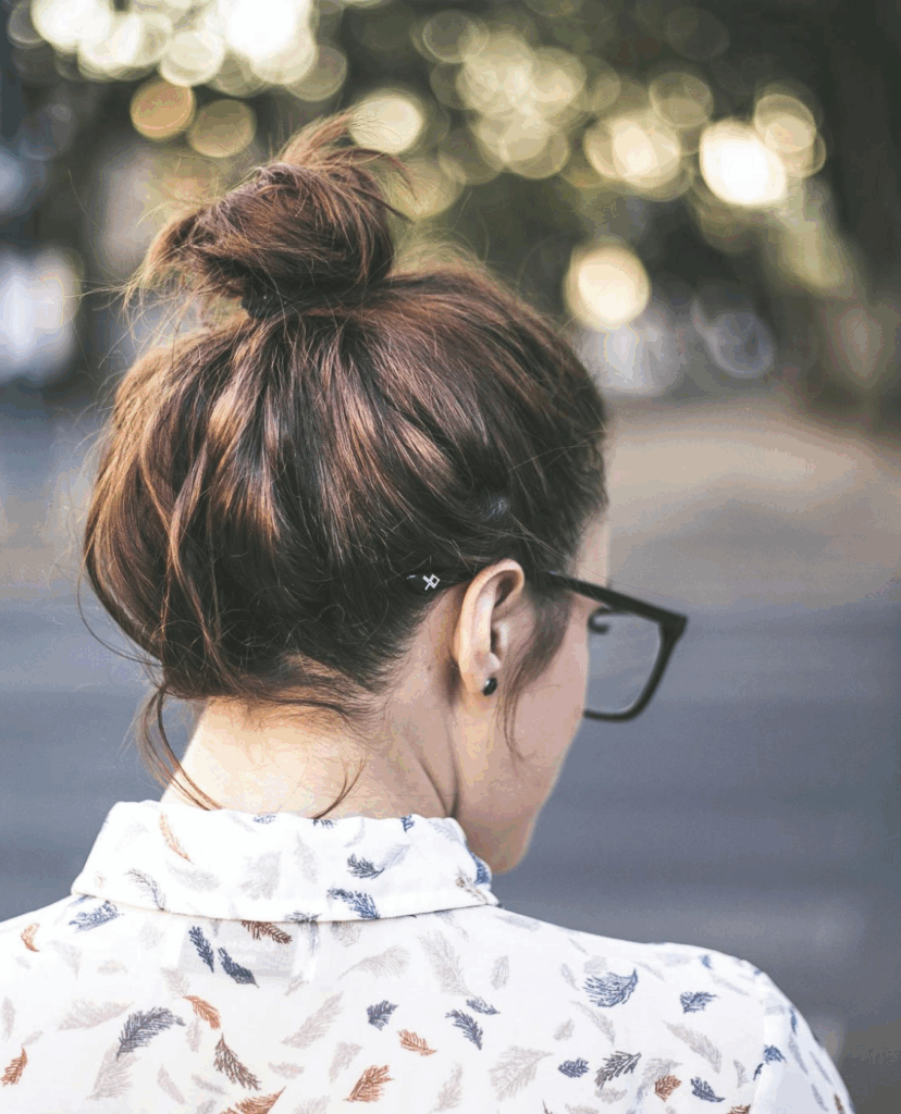 Am Bild: Frau mit Gesicht abgewandt, Brillenträgerin