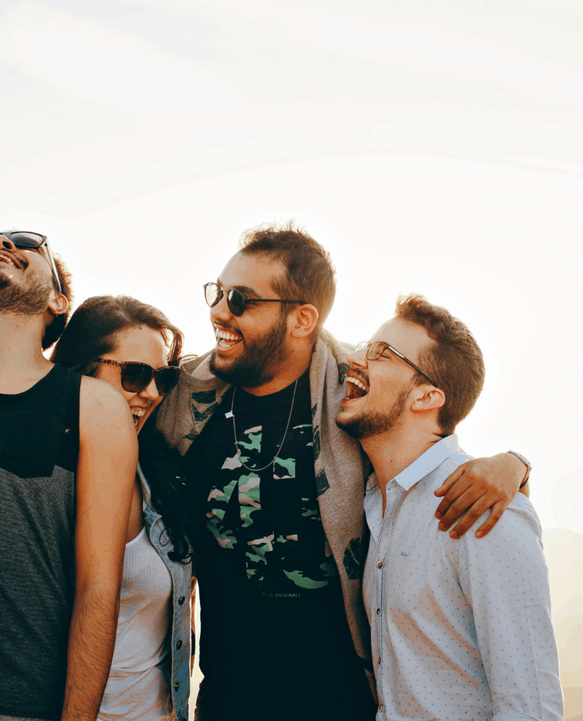 Am Bild vier lachende junge Menschen, die sich umarmen