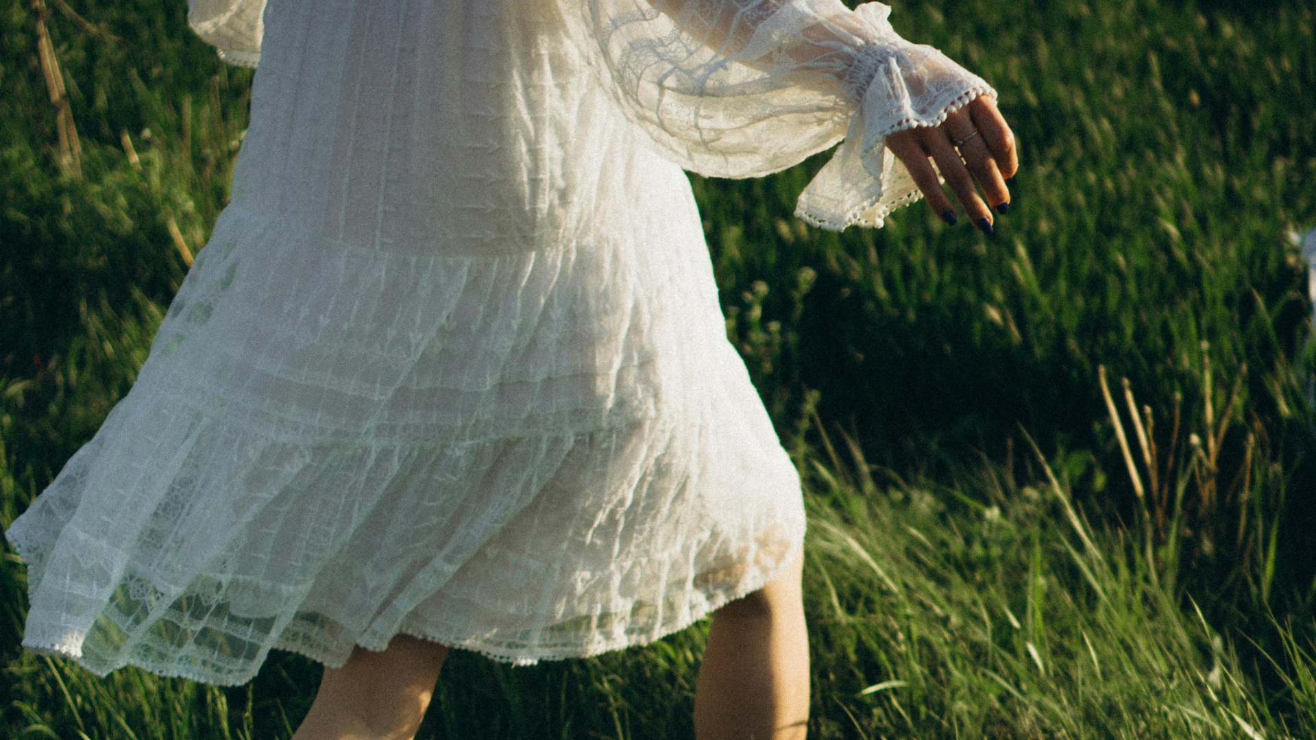 Eine Frau im weißen Kleid läuft durch Wiese