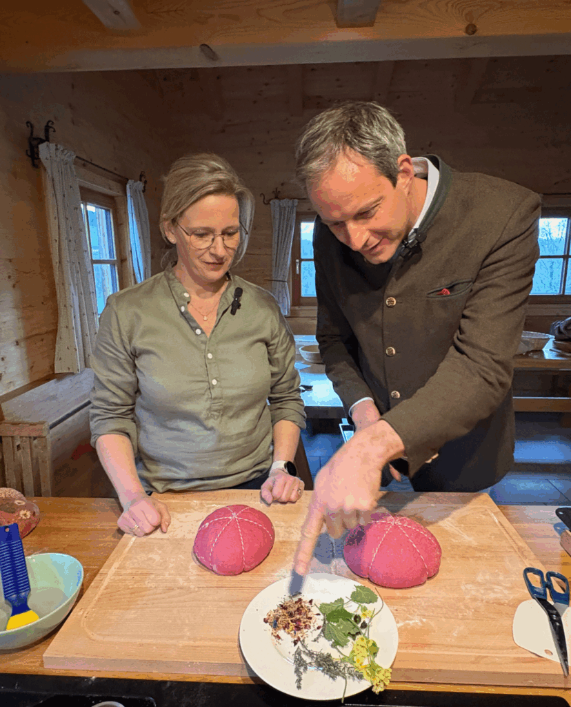 Bäuerin bäckt pinkes Muttertagsbrot mit einem Seminarteilnehmer
