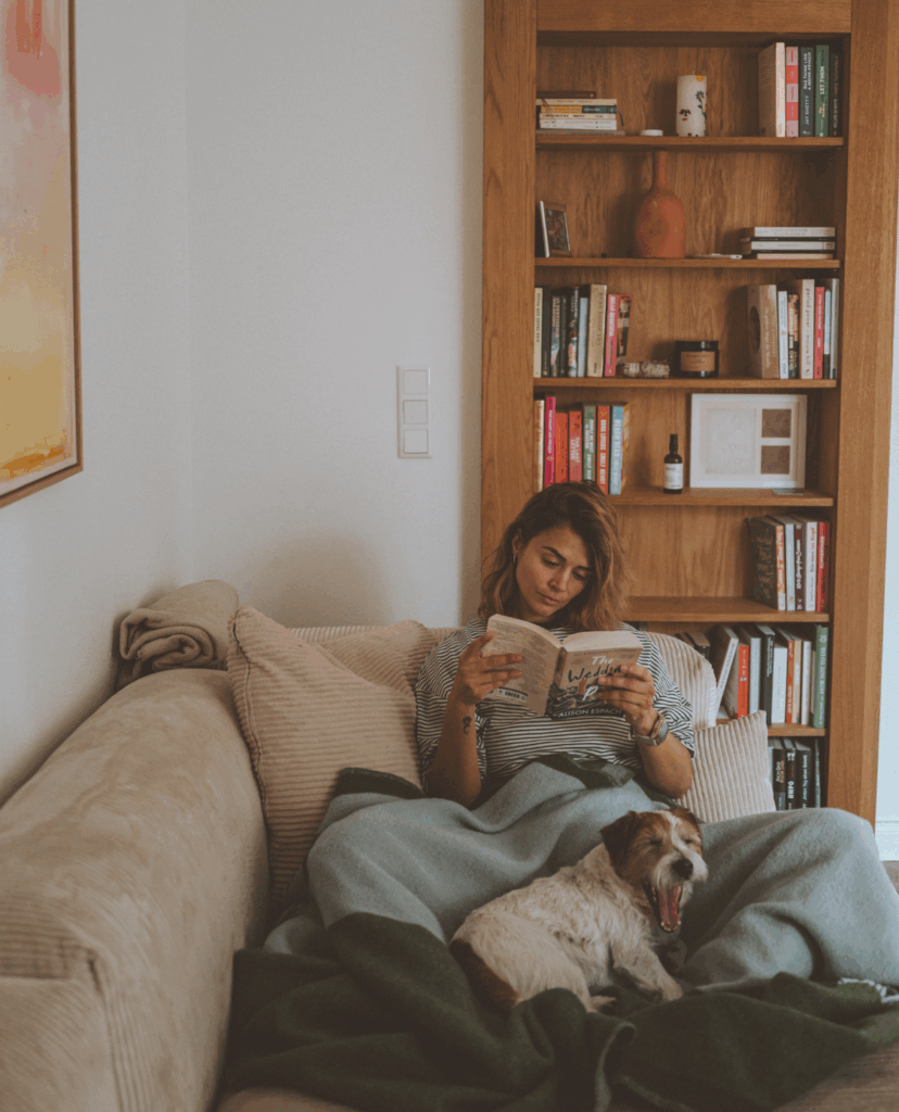 Influencerin Nina Radman auf der Couch mit einem Buch in der Hand