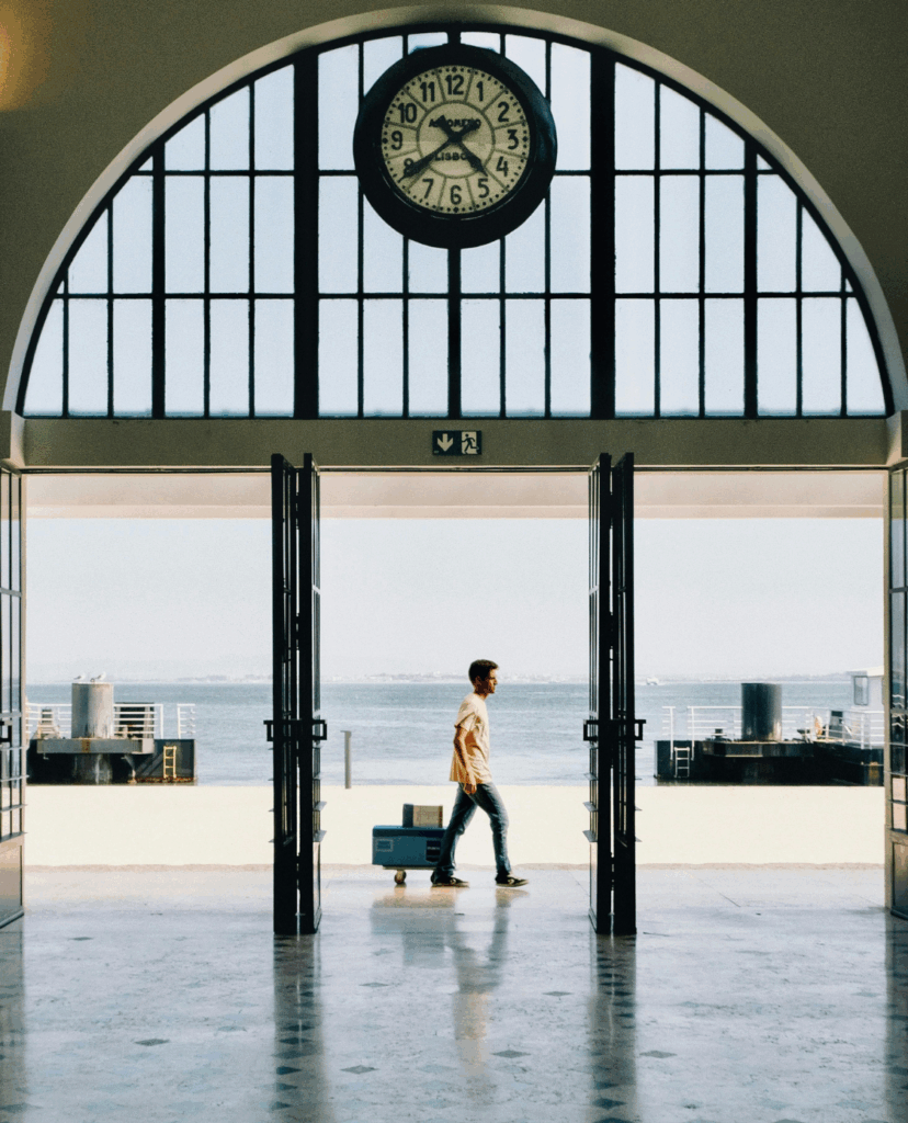 An einem Bahnhof am Meer, Mann geht mit Koffern