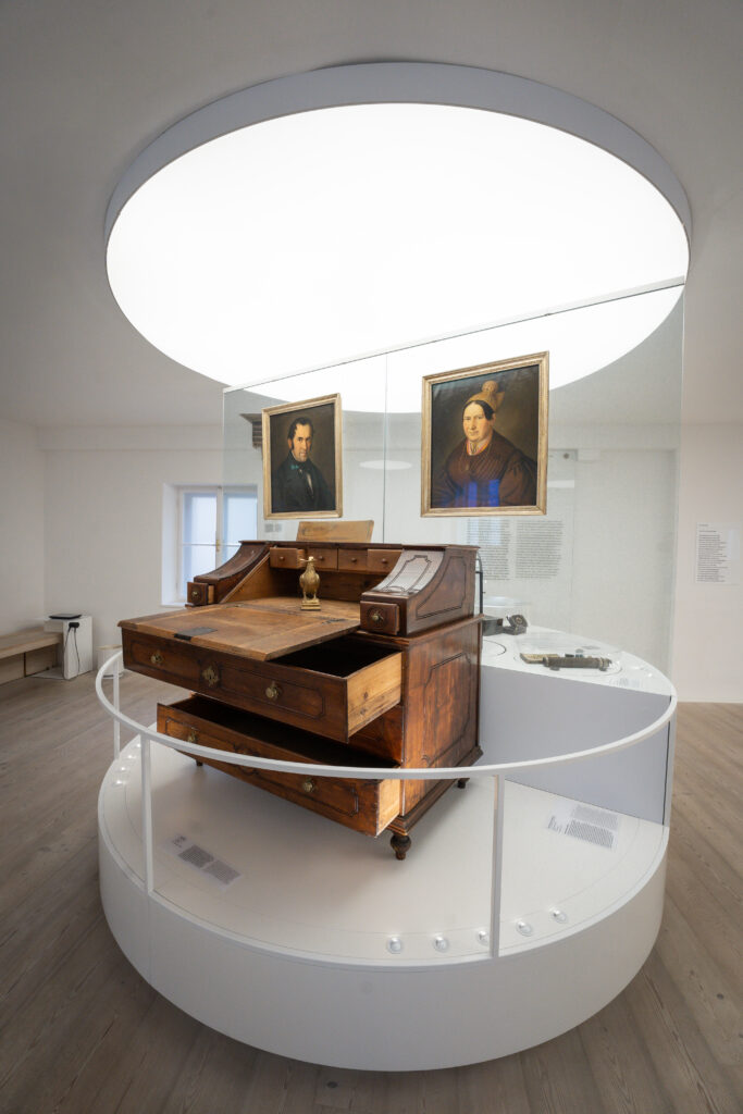 Schreibtisch und 2 Portraits, links Franz Xaver Gruber und rechts seine Gattin - aus dem Stille Nacht Museum Hallein