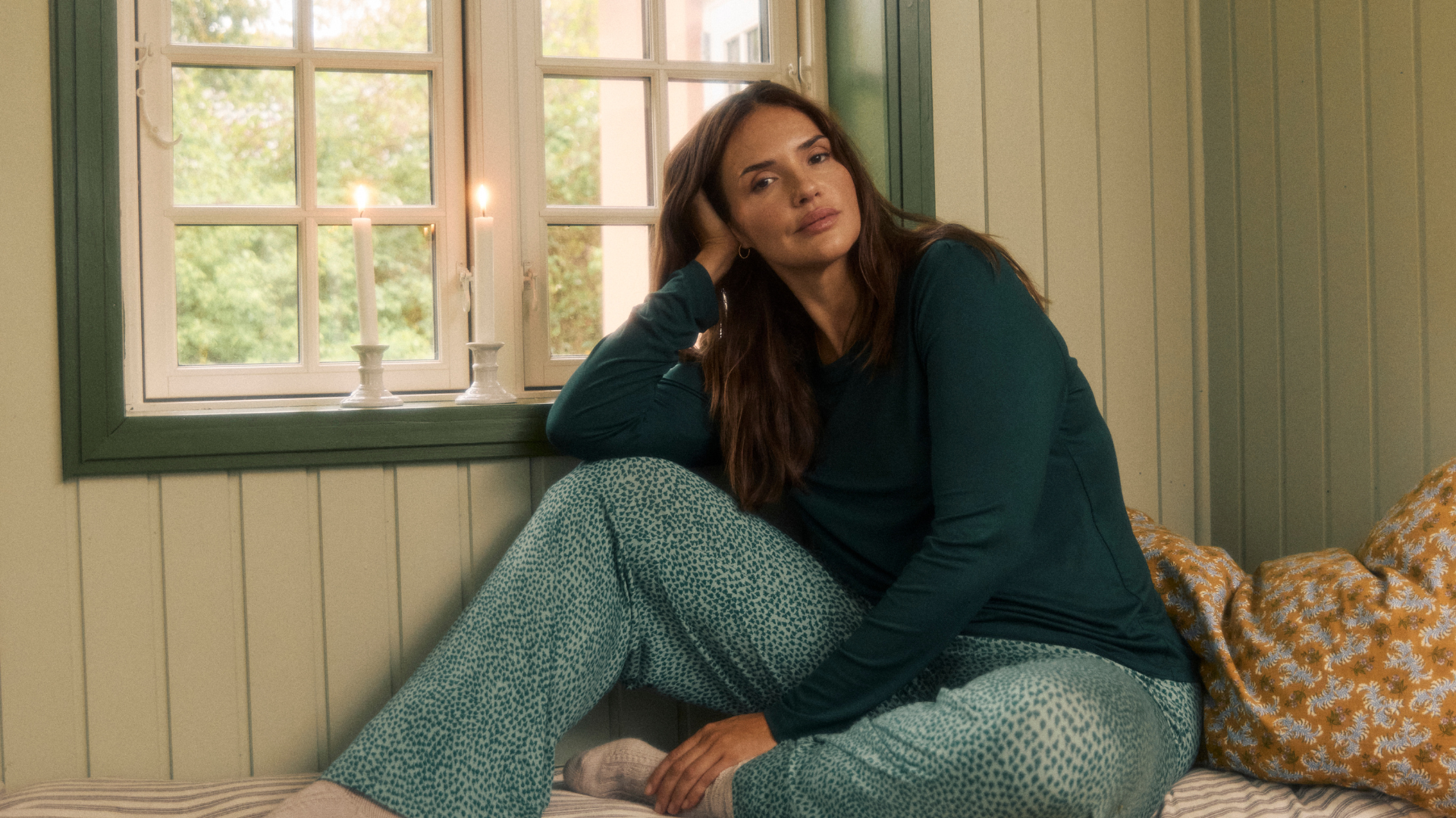 Frau im Pyjama vor einem Fenster